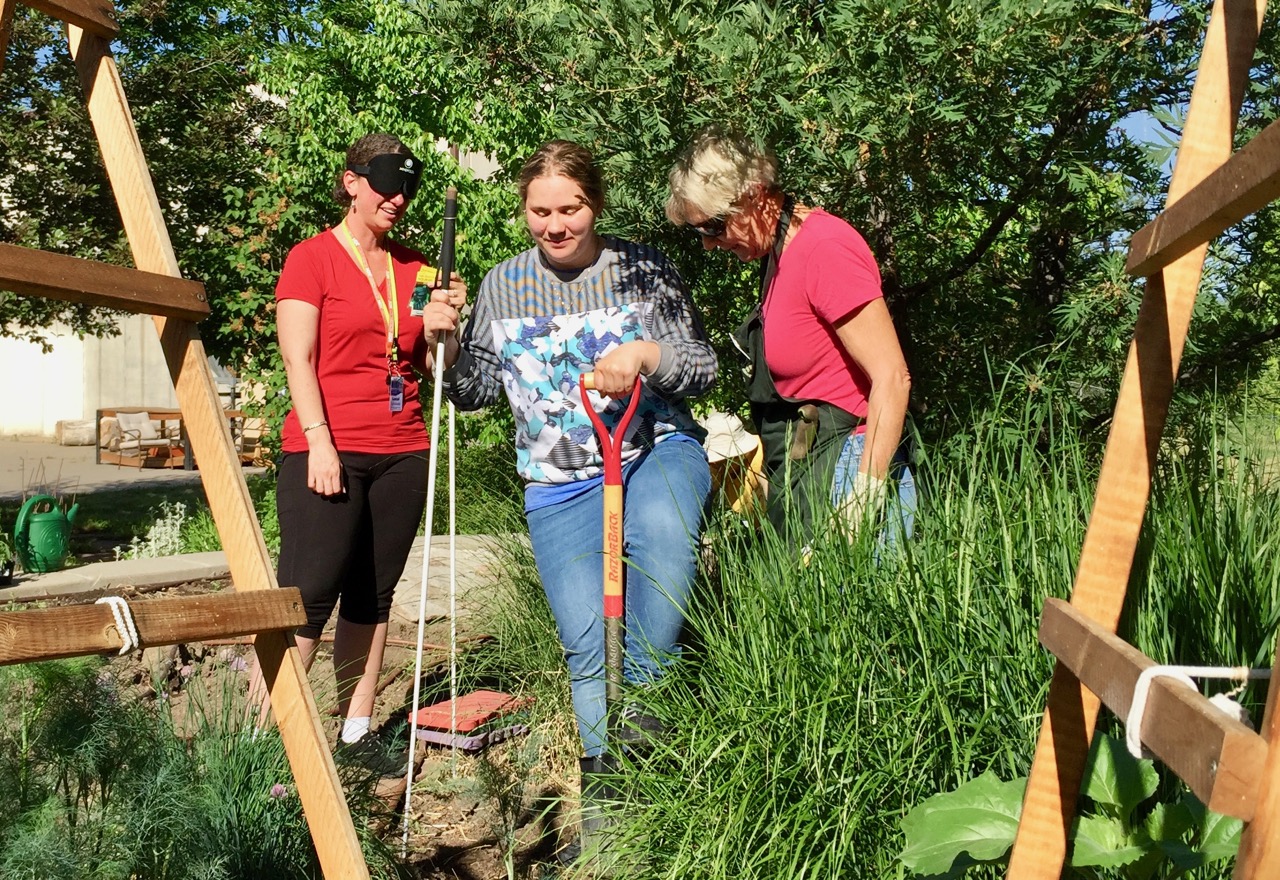Amber using a shovel in the garden for the 1st time with Annette and Barb
